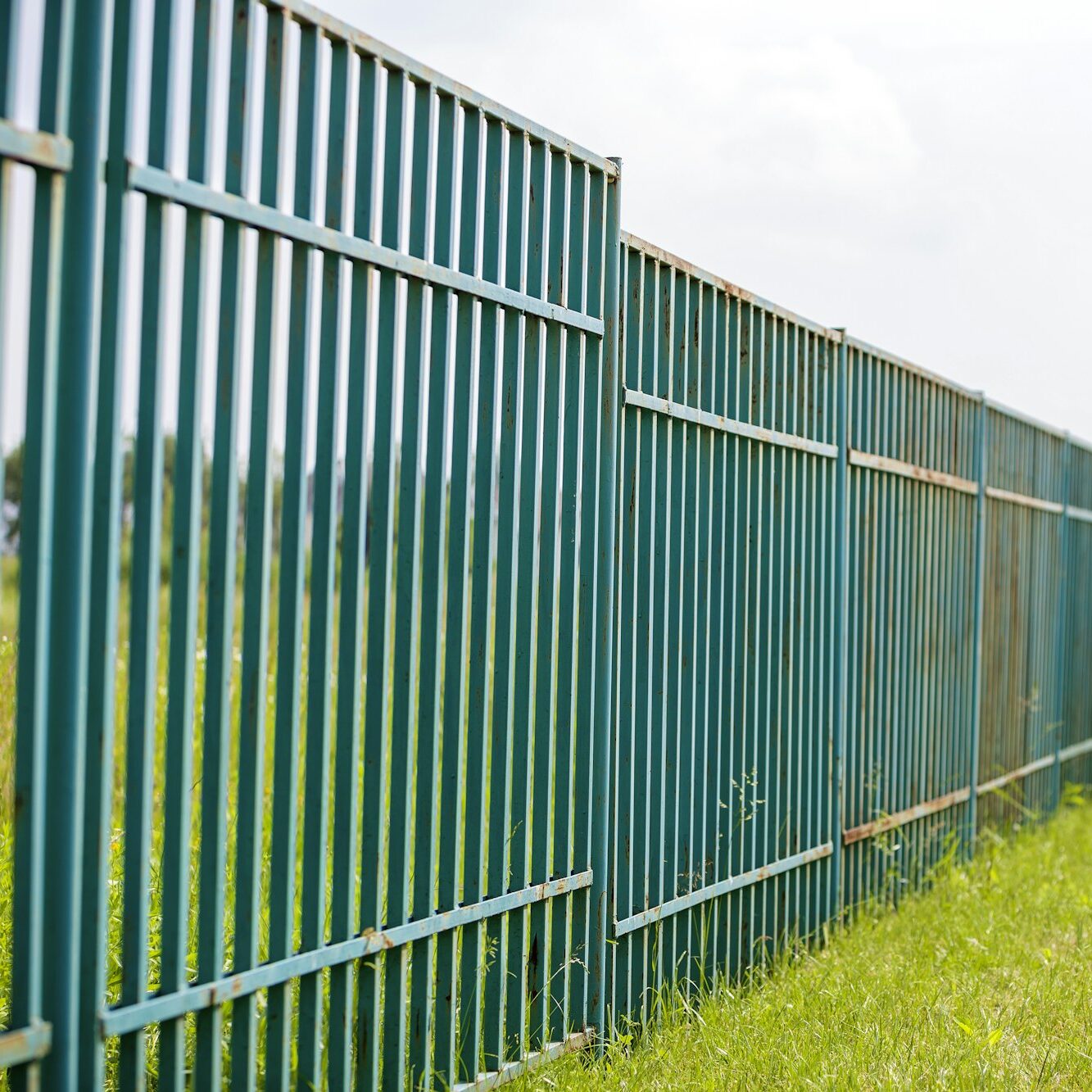 Long rusty old metalic fence.